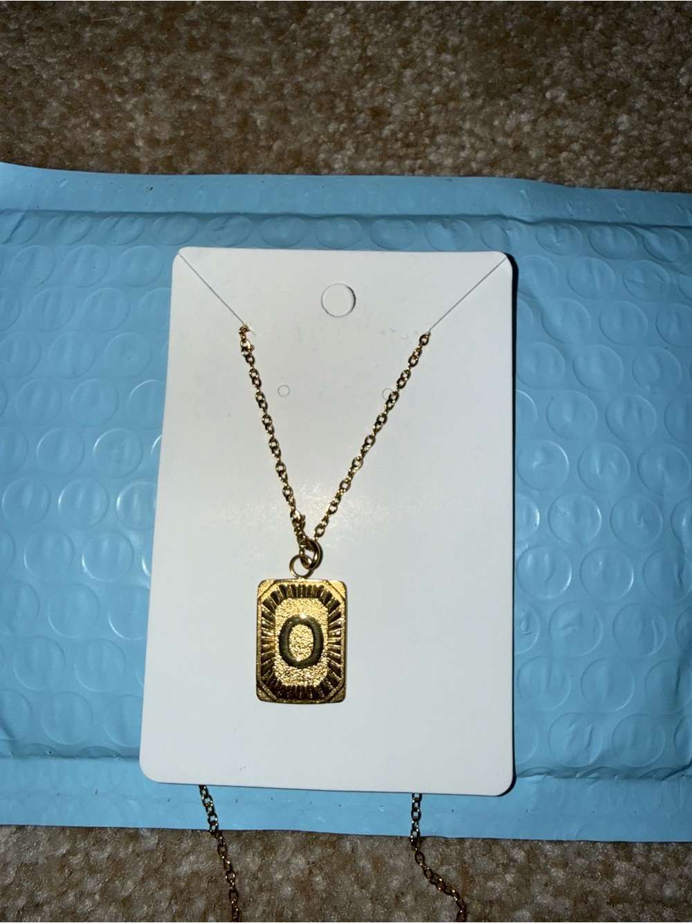 Gold Rectangle Pendant Necklace with Textured Detail. Letter O